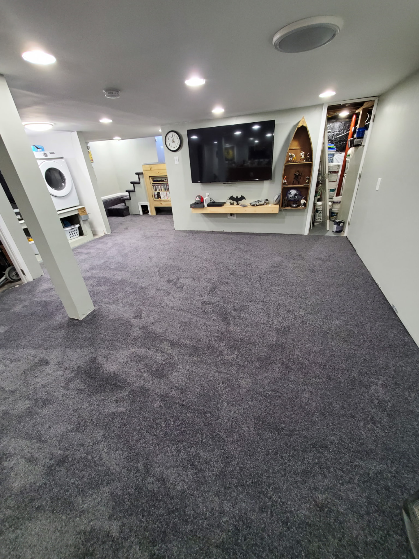 Finished basement with gray carpet, recessed lighting and a wall-mounted TV