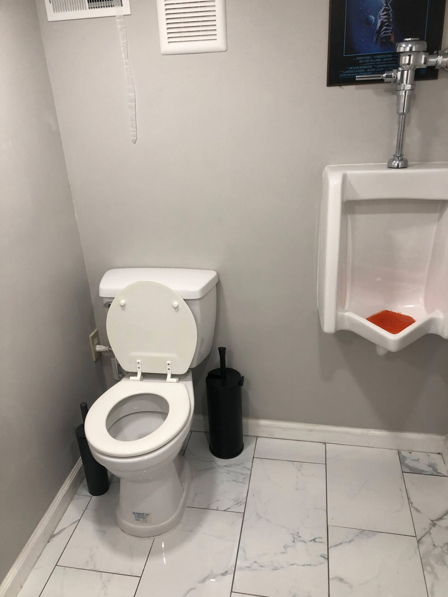 Basement half bath with marble-look floor tile, toilet and urinal