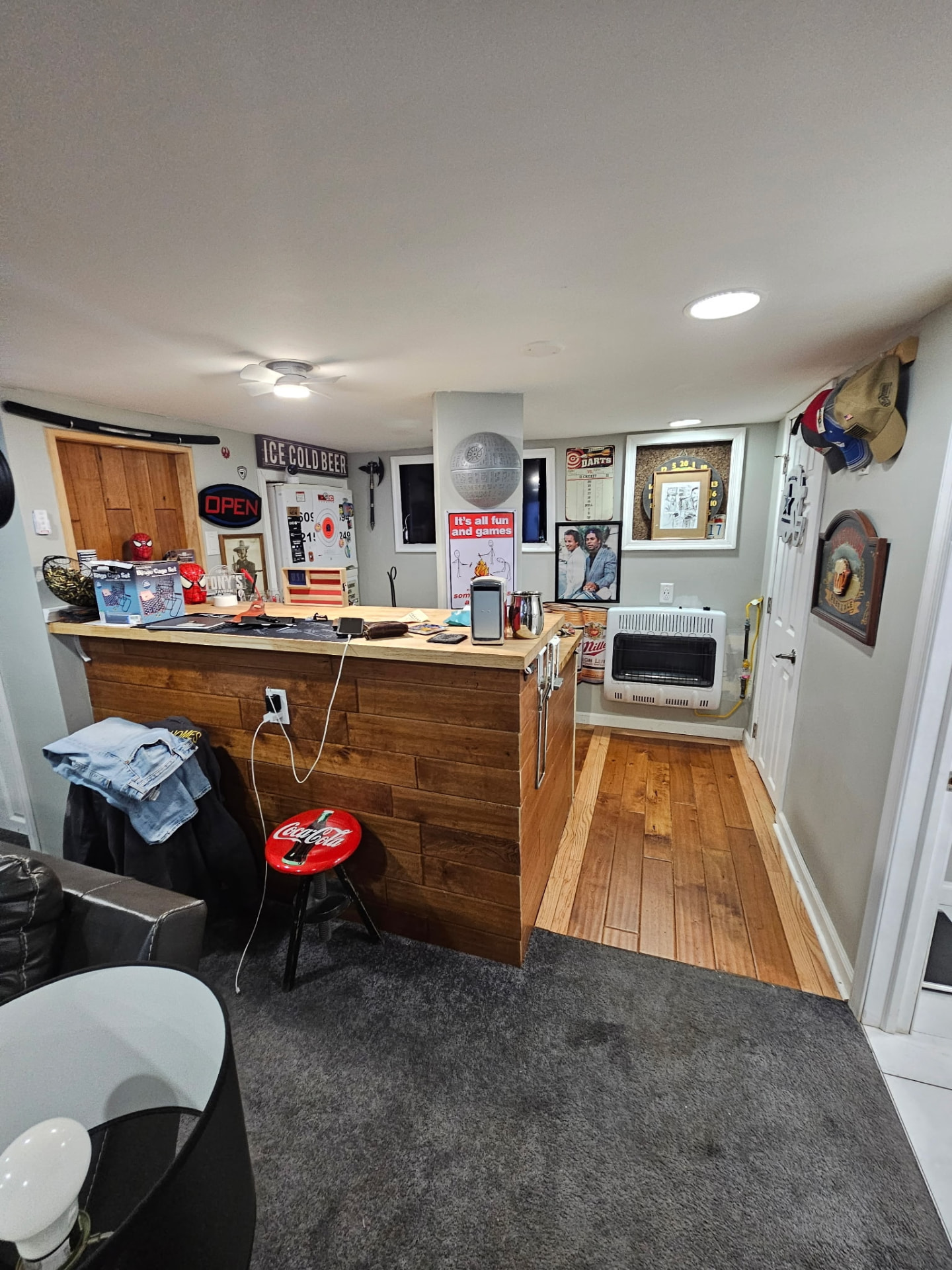 Basement bar finished with wood plank paneling beside a wood floor